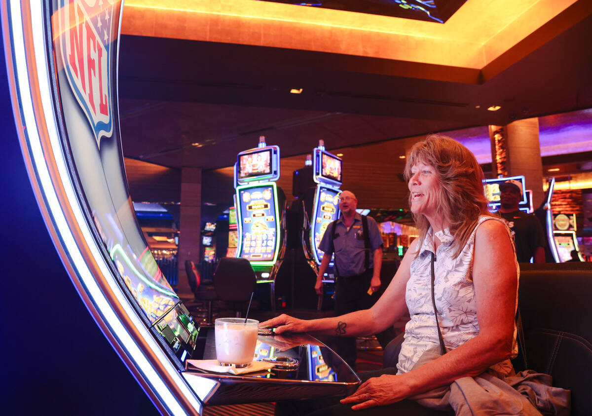Pam Hillaker, of Idaho, plays the first Vegas NFL slot machine at the M Resort in Las Vegas, Mo ...