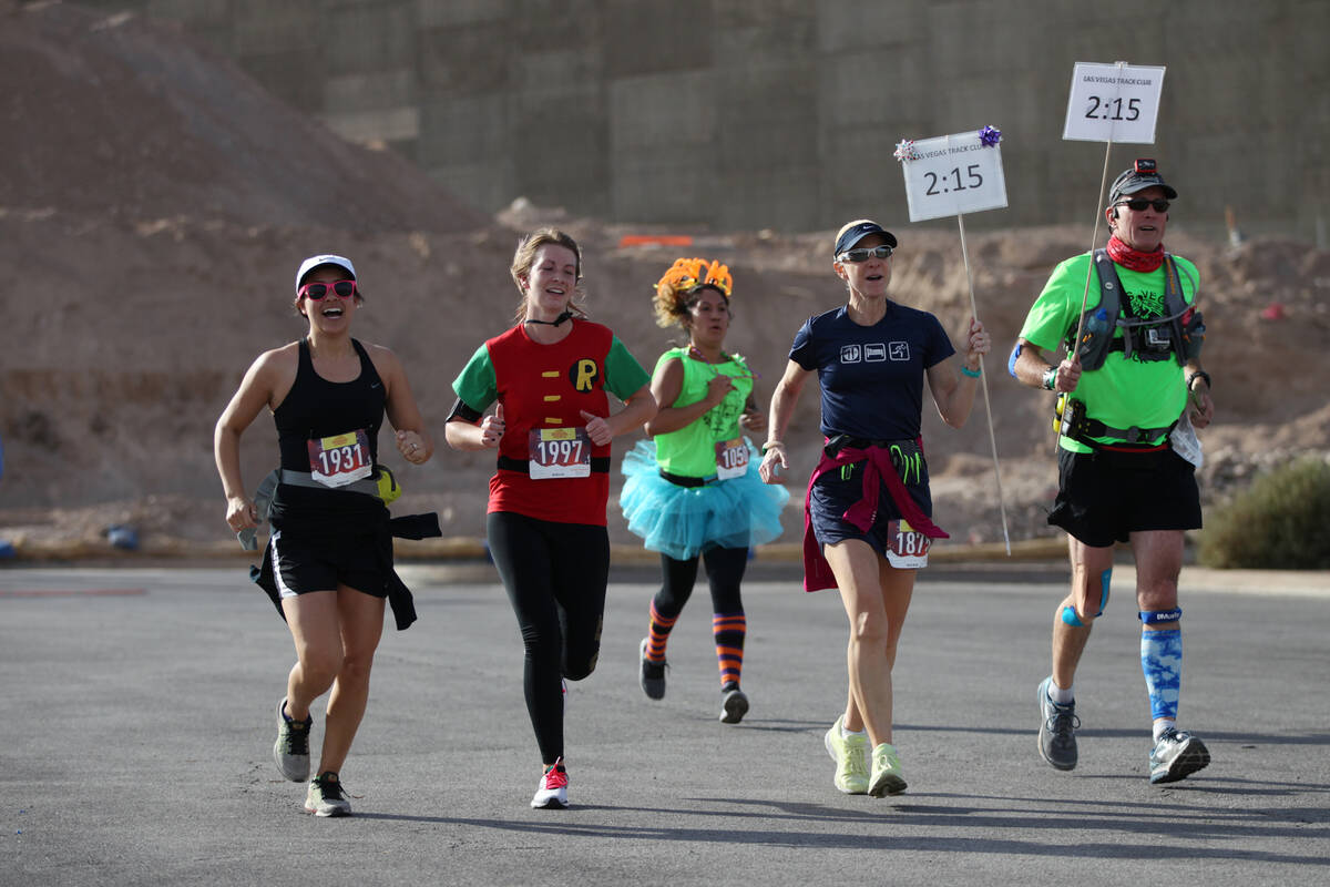 Runners sprint to the finish line during the Halloween half marathon and 5K runs at Fiesta Hend ...