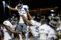 Desert Pines wide receiver Niqel Junor (3) is hoisted by his teammates in celebration after he ...