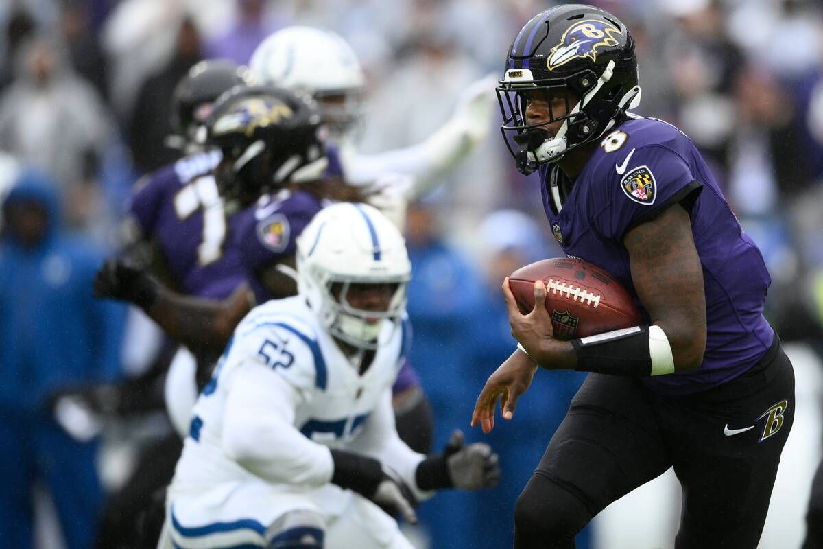 Baltimore Ravens quarterback Lamar Jackson runs during the first half of an NFL football game a ...