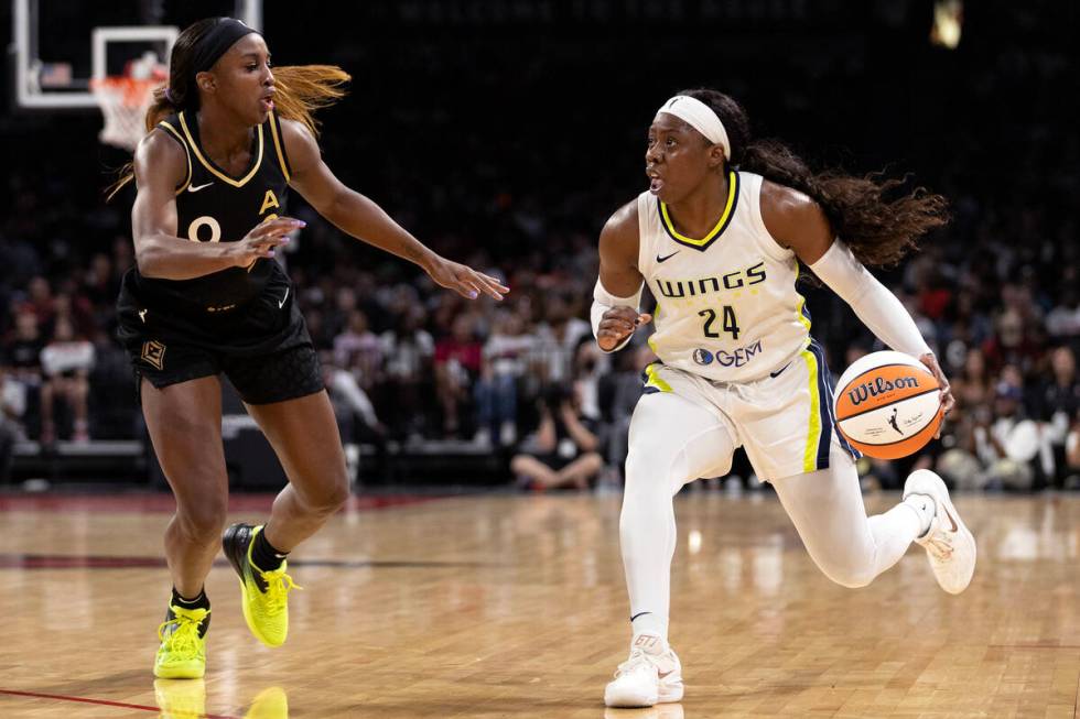 Dallas Wings guard Arike Ogunbowale (24) dribbles against Las Vegas Aces guard Jackie Young (0) ...