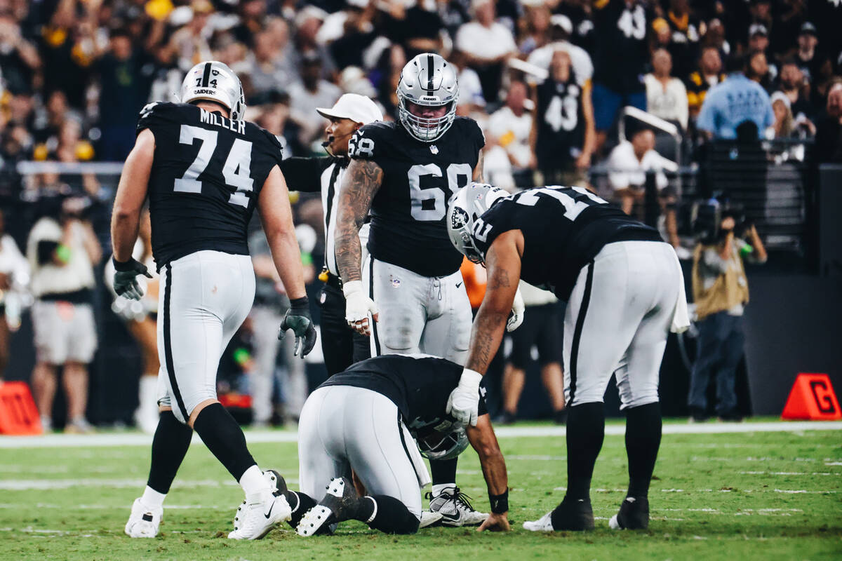 Raiders quarterback Jimmy Garoppolo (10) is comforted by teammate Jermaine Eluemunor (72) after ...