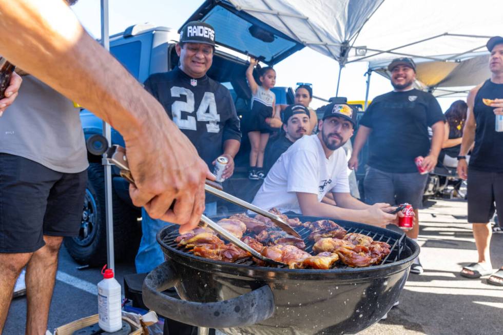 Raiders fans grill up some chicken during tailgating before the first half of the Raiders versu ...