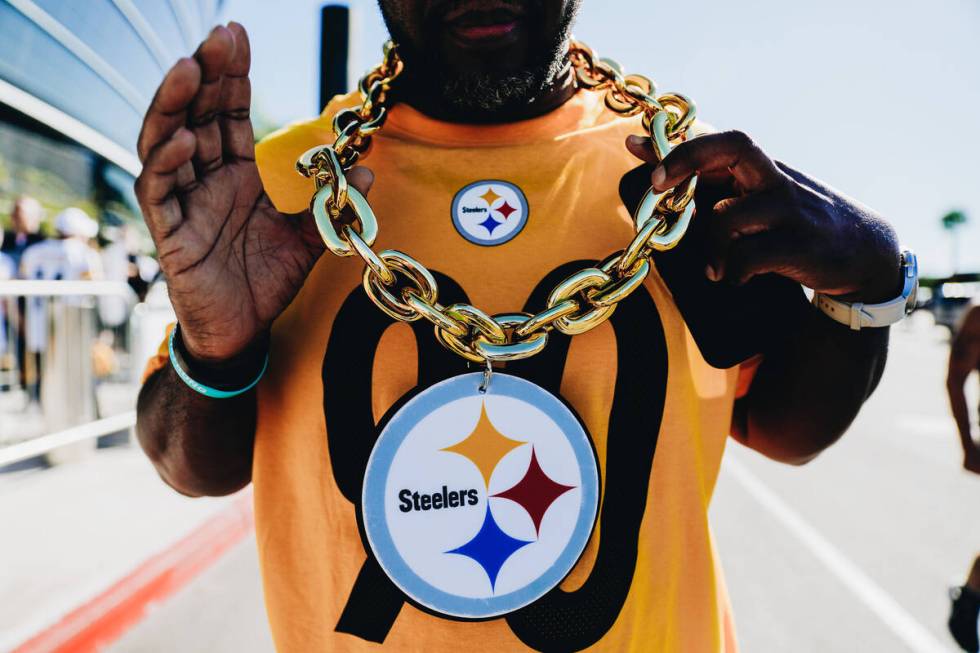 Pittsburgh Steelers fan Amir Smith shows off his necklace before the start of an NFL football g ...