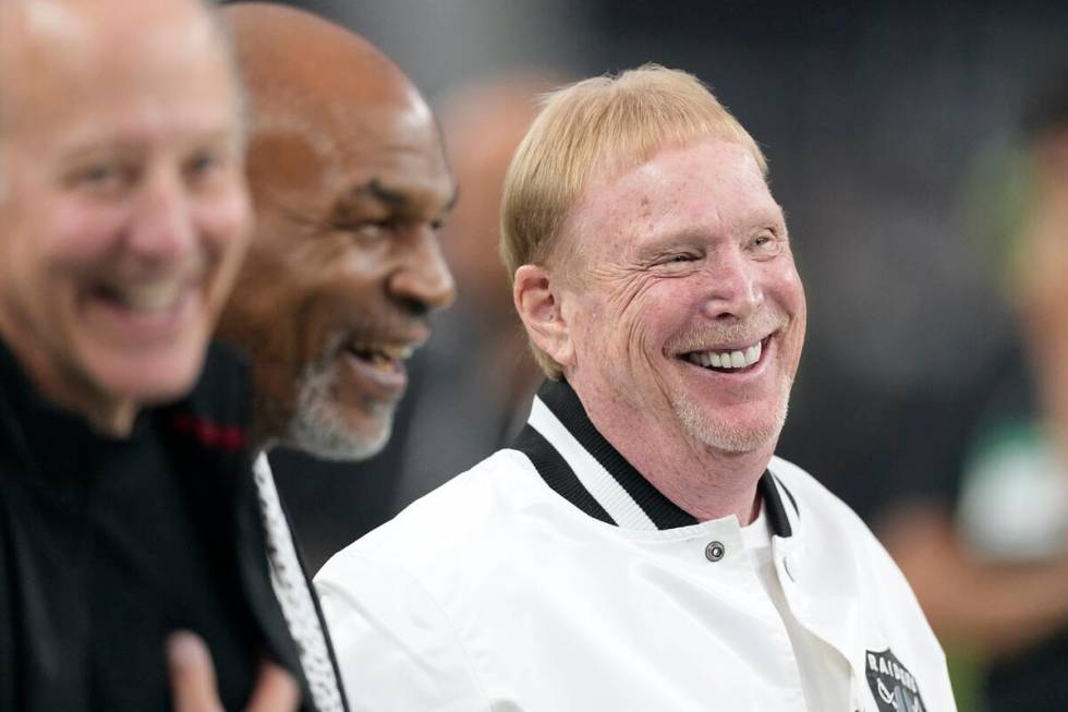 Las Vegas Raiders owner Mark Davis, right, smiles on the field next to former professional boxe ...