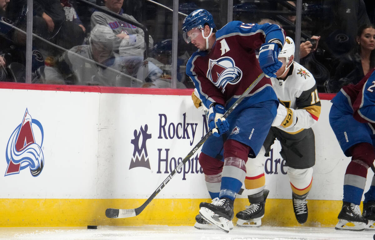 Colorado Avalanche center Ryan Johansen, left, clears the puck as Vegas Golden Knights center M ...