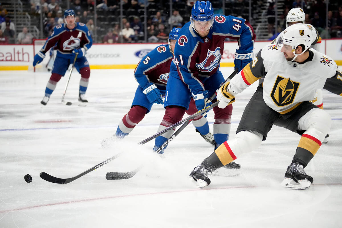 Vegas Golden Knights defenseman Nicolas Hague, right, knocks the puck away from Colorado Avalan ...