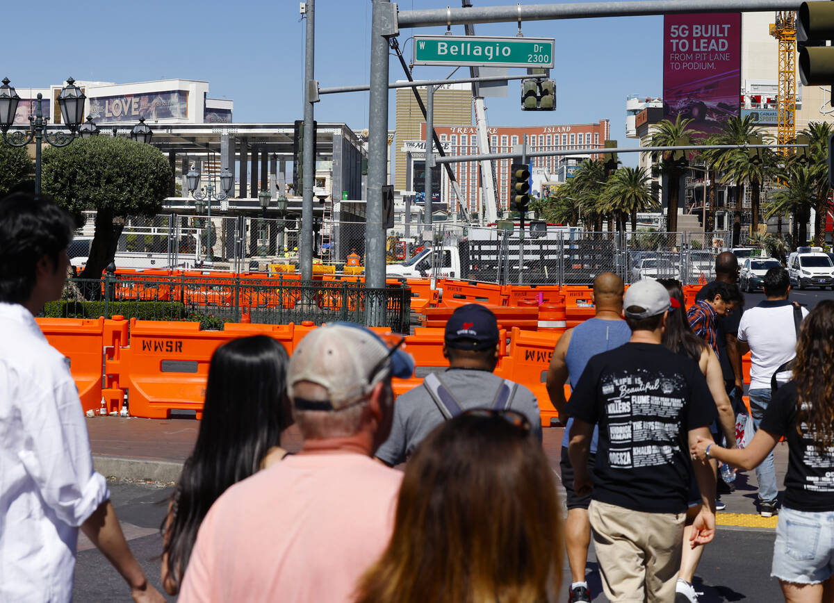 Tourists walk past the Formula 1 construction site at the Fountains of Bellagio, on Monday, Sep ...