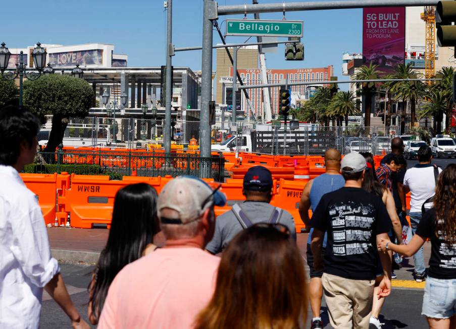 Tourists walk past the Formula 1 construction site at the Fountains of Bellagio, on Monday, Sep ...