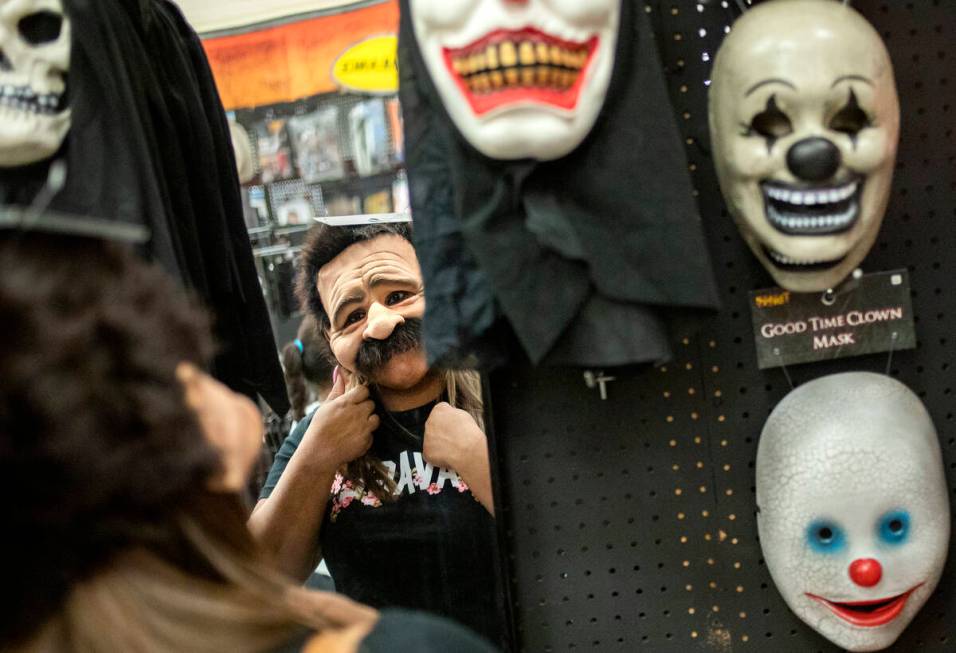 Laura Silva of St. George, Utah tries on a mask for her upcoming Halloween costume on Wednesday ...