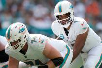 Miami Dolphins quarterback Tua Tagovailoa prepares to take the snap as offensive tackle Liam Ei ...