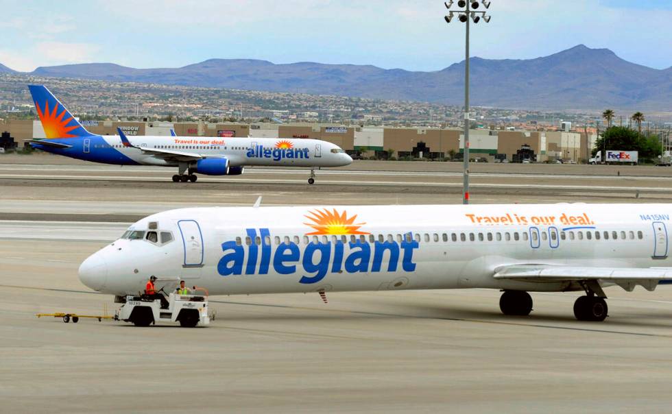 FILE- In this May 9, 2013, file photo, two Allegiant Air jets taxi at McCarran International Ai ...