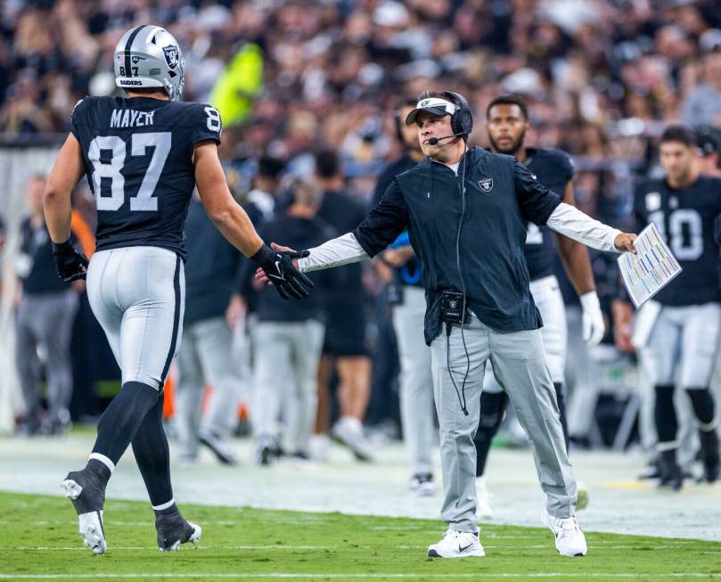 Raiders tight end Michael Mayer (87) gets a hand slap from Raiders Head Coach Josh McDaniels af ...