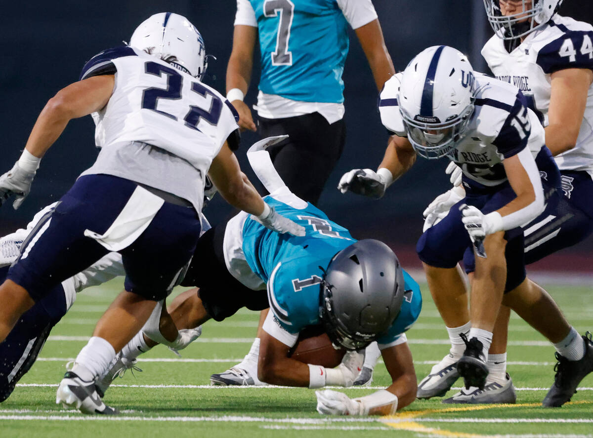 Silverado High Tristan Hudson (1) tackled by Shadow Ridge High Diego Madrid (22) and Aaron Cove ...