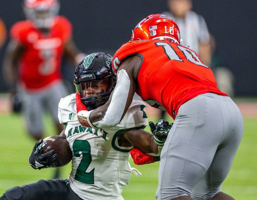 Hawaii running back Tylan Hines (2) is collared by UNLV linebacker Fred Thompkins (10) during t ...