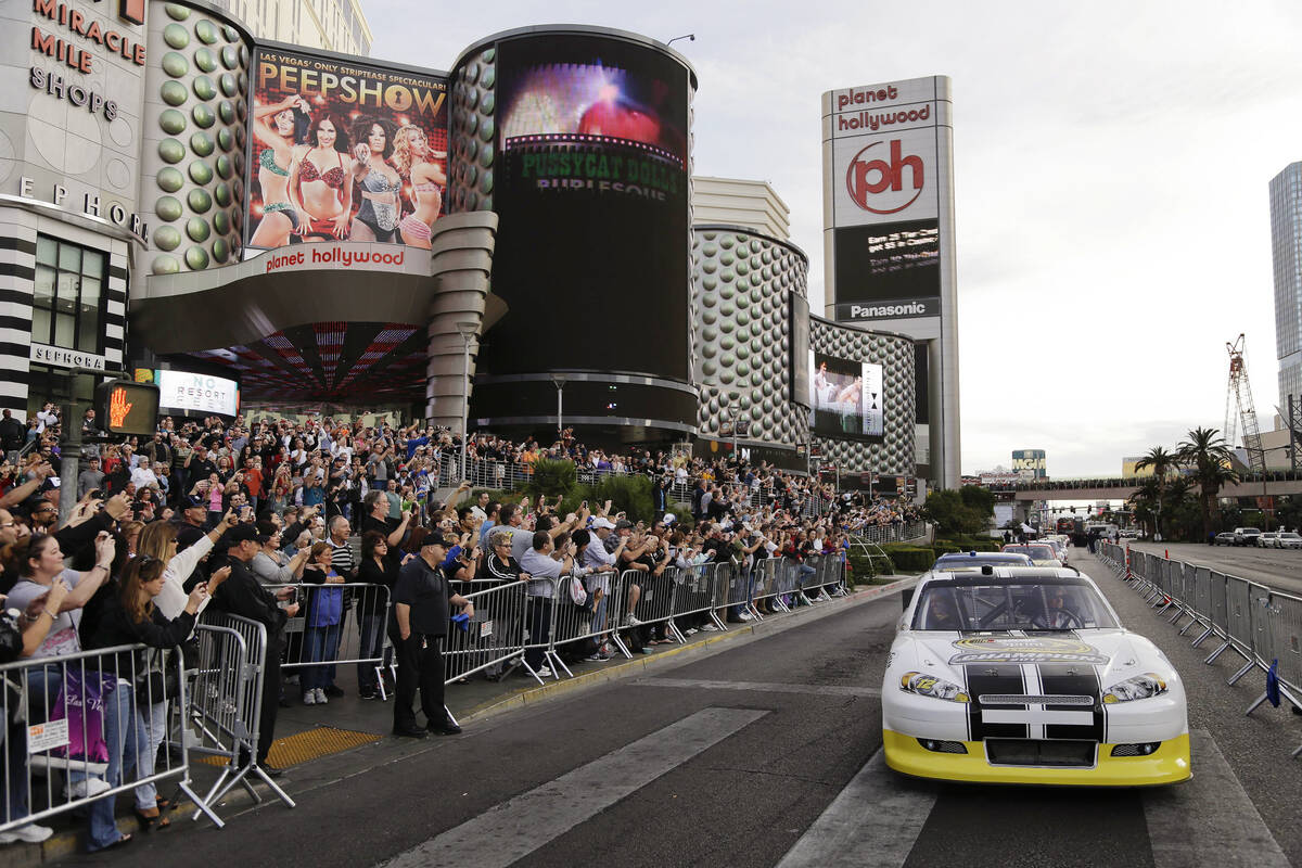 Fans and tourists cheer the drivers at the start of the Nascar Awards Week victory lap along th ...
