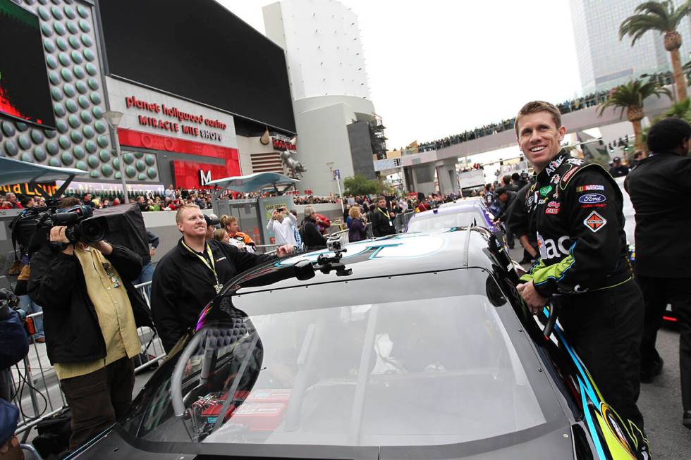Driver Carl Edwards climbs into his car during NASCAR Champion's Week Victory Lap on the Las Ve ...