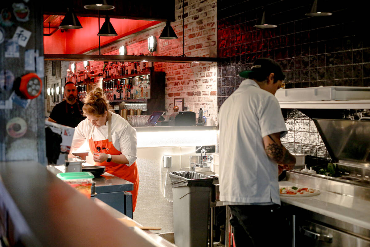 Chef Adriana Davis, left, and pizzaiolo Josh Gooss, right, prepare pizzas at ØØ Pie & ...