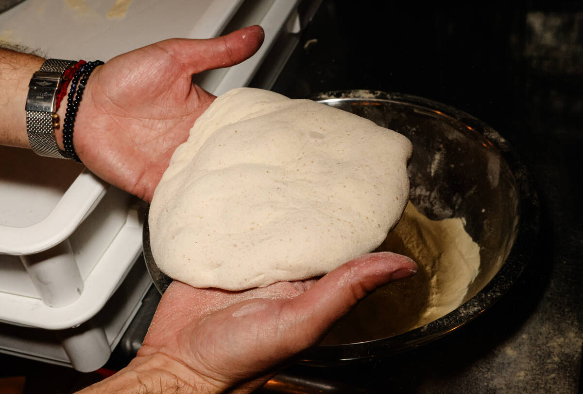 World champion pizza maker Michael Vakneen handles dough for a pizza at his new restaurant, &#x ...