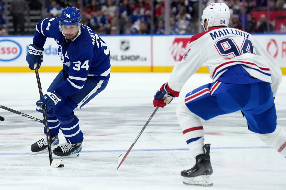 Toronto Maple Leafs centre Auston Matthews (34) moves the puck under the eye of Montreal Canadi ...