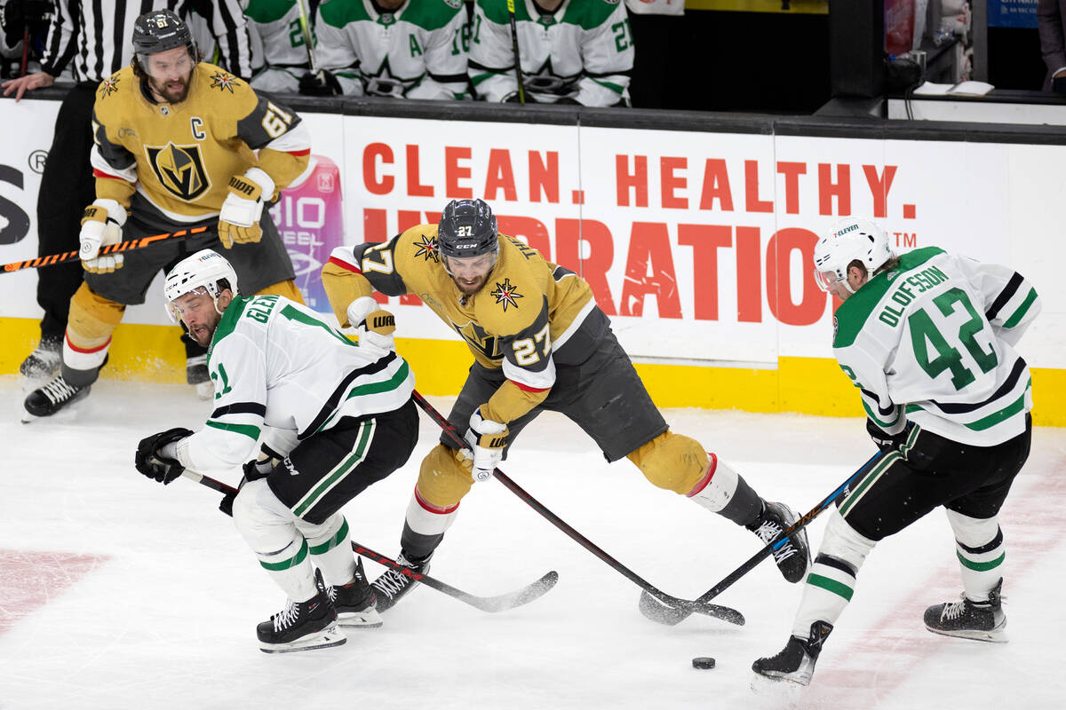 Golden Knights defenseman Shea Theodore (27) battles for the puck with Dallas Stars center Luke ...