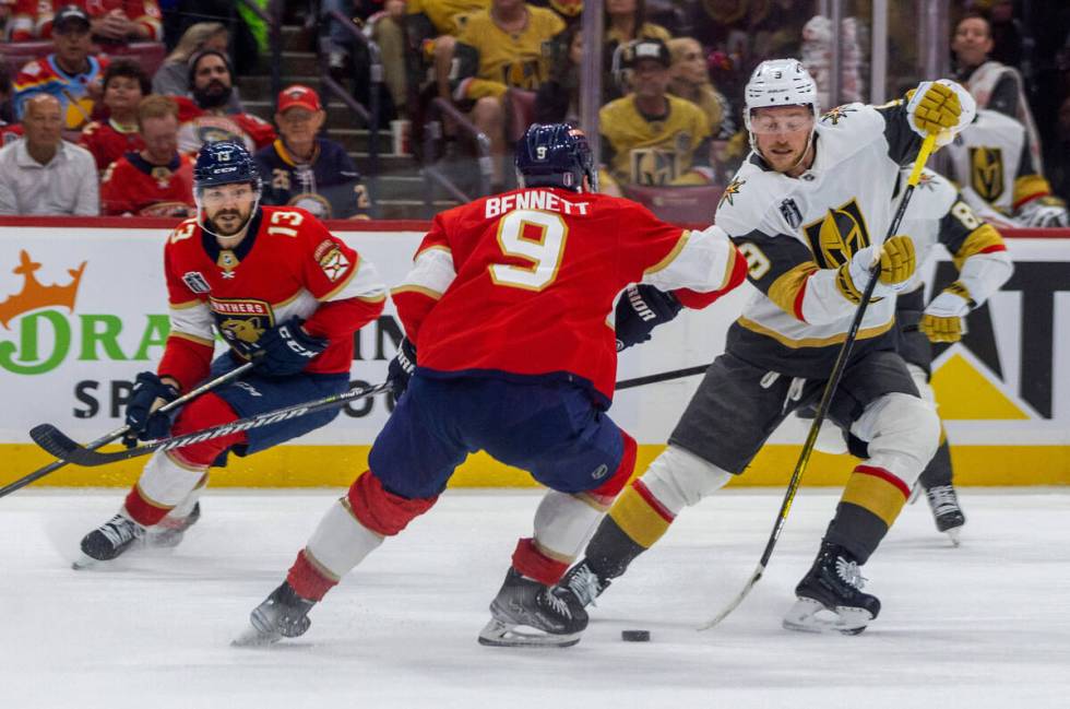 Golden Knights center Jack Eichel (9) maneuvers around Florida Panthers center Sam Bennett (9) ...