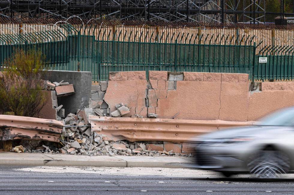 A motorist drives past a damaged wall after a fatal crash near the intersection of Charleston ...