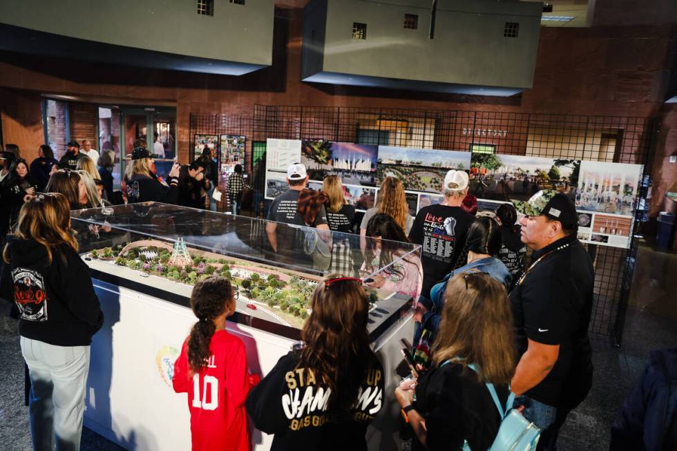 People gather around a diorama of the future memorial that will be on the festival grounds wher ...