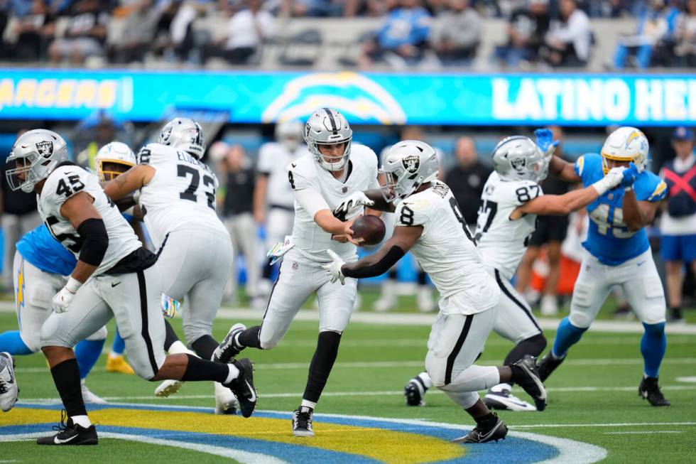 Las Vegas Raiders quarterback Aidan O'Connell hands off to running back Josh Jacobs during the ...