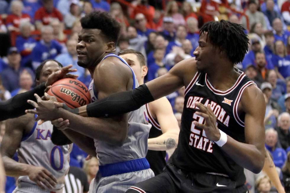 Kansas center Udoka Azubuike, left, rebounds against Oklahoma State forward Kalib Boone, right, ...