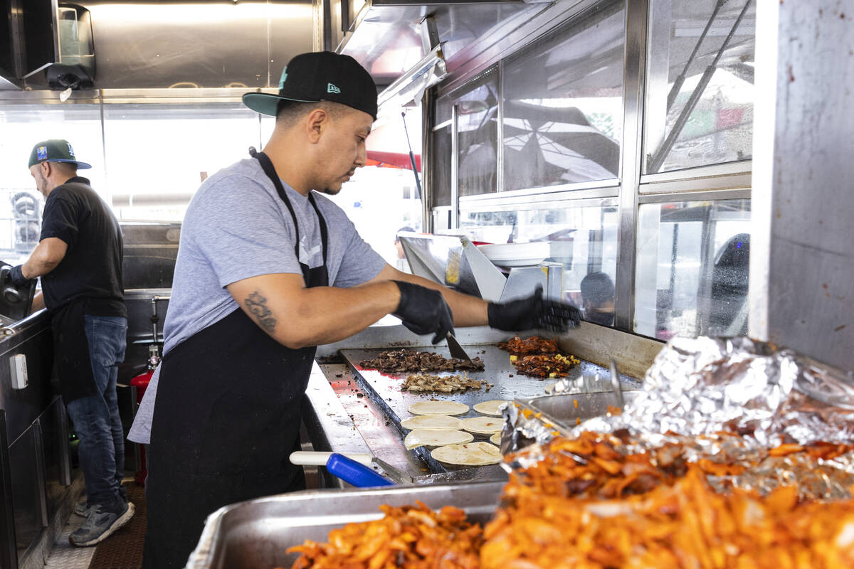 Rudi Larios prepares tacos inside Casa del Sabor food truck at the corner of Bonanza Road and L ...