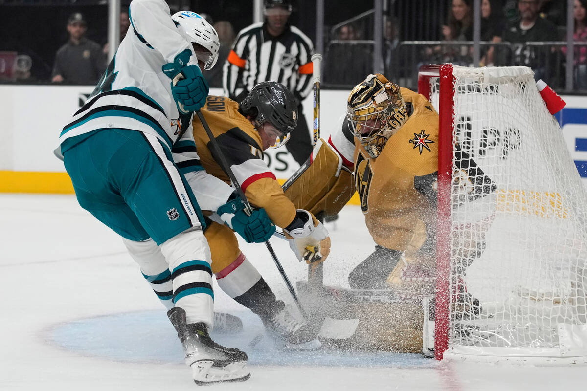 San Jose Sharks' Givani Smith, left, attempts a shot on Vegas Golden Knights goaltender Adin Hi ...