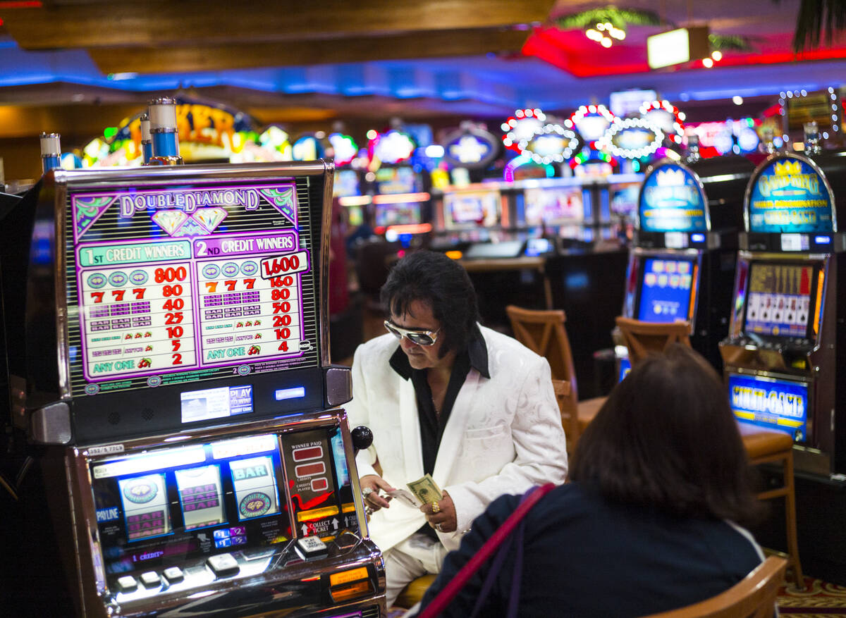 Elvis tribute artist Bobby Presley, of Modesto, Calif., sits by slot machines at CasaBlanca Res ...