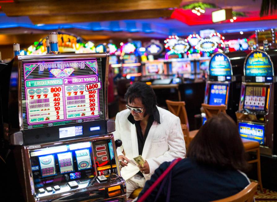 Elvis tribute artist Bobby Presley, of Modesto, Calif., sits by slot machines at CasaBlanca Res ...