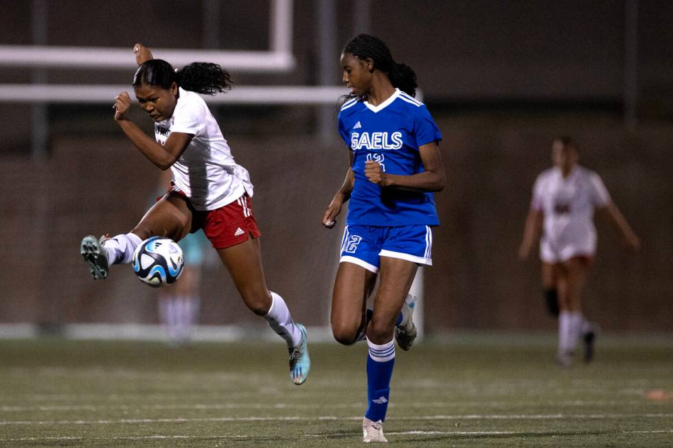 Liberty's Danica Key, left, jumps to kick the ball away from Bishop Gorman midfielder Amiya War ...