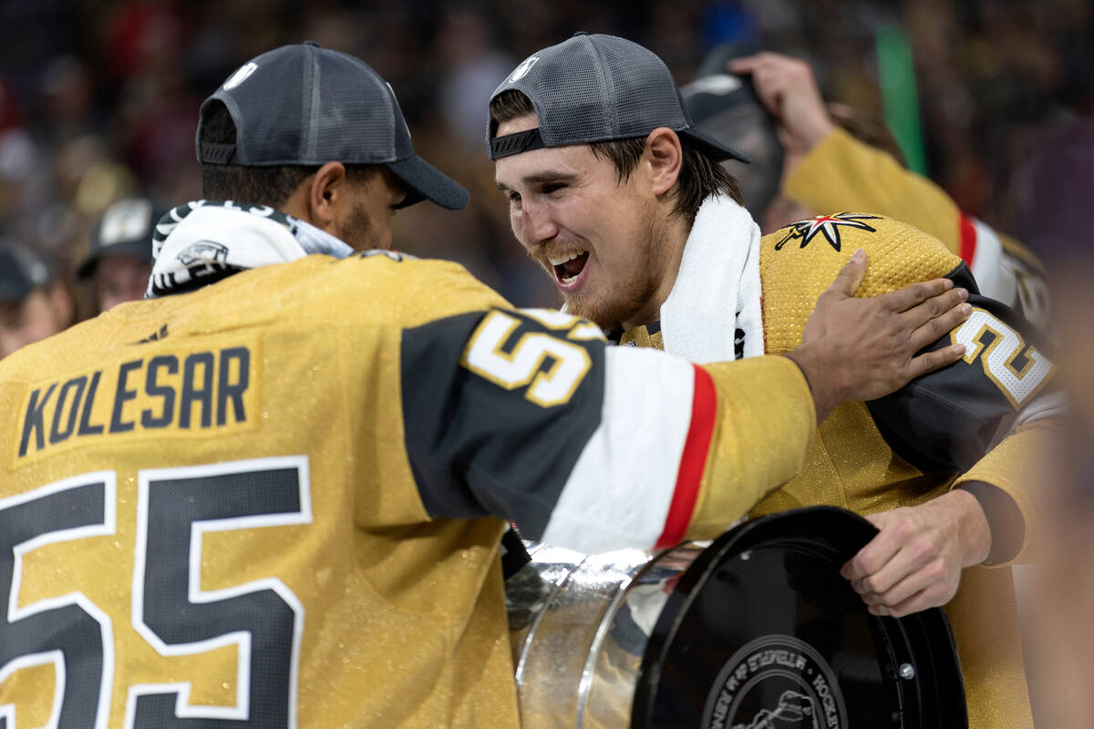 Golden Knights right wing Keegan Kolesar (55) hands off the Stanley Cup to defenseman Zach Whit ...