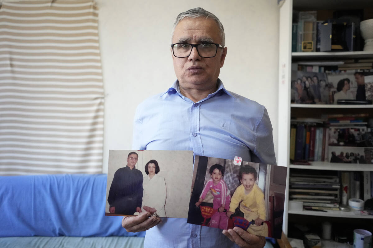 Narges Mohammadi's husband Taghi Rahmani shows a picture of him and his wife, and one of their ...