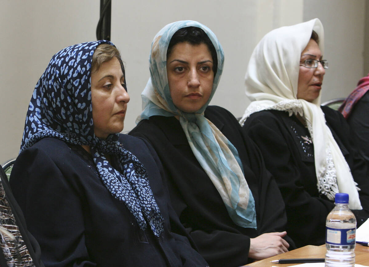 FILE - Prominent Iranian human rights activist Narges Mohammadi, center, sits next to Iranian N ...