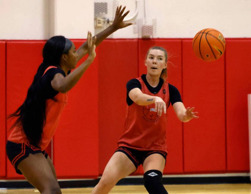 UNLV Lady Rebels Ashley Scoggin (0) passes the ball as forward Macie James (20) defends during ...