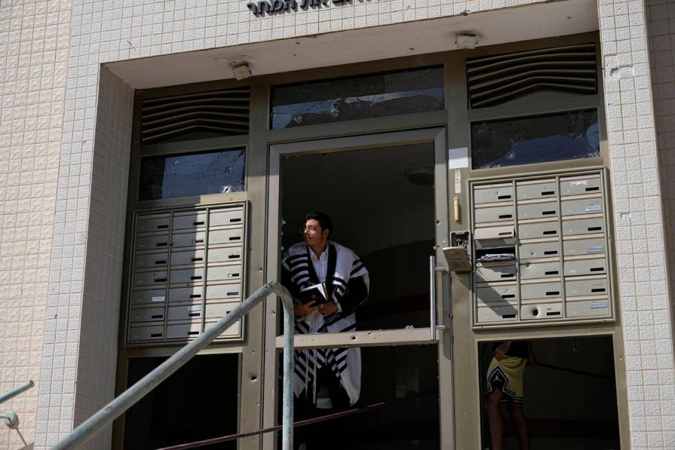 An ultra-Orthodox Jew peers out of a building after a rocket attack from the Gaza Strip in Ashk ...