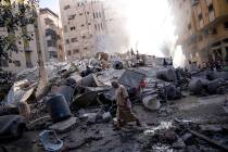 Palestinians inspect the rubble of a building after it was struck by an Israeli airstrike, in G ...