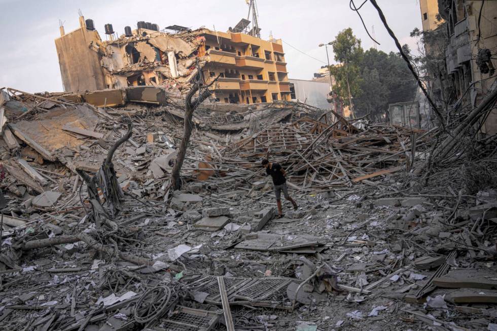 Palestinians inspect the rubble of a building after it was struck by an Israeli airstrike, in G ...