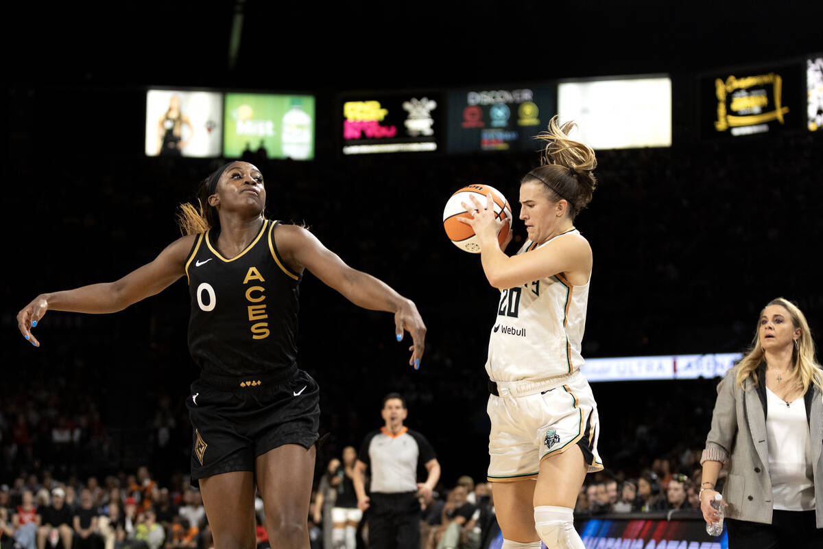 Las Vegas Aces guard Jackie Young (0) attempts to swat a shot down by New York Liberty guard Sa ...