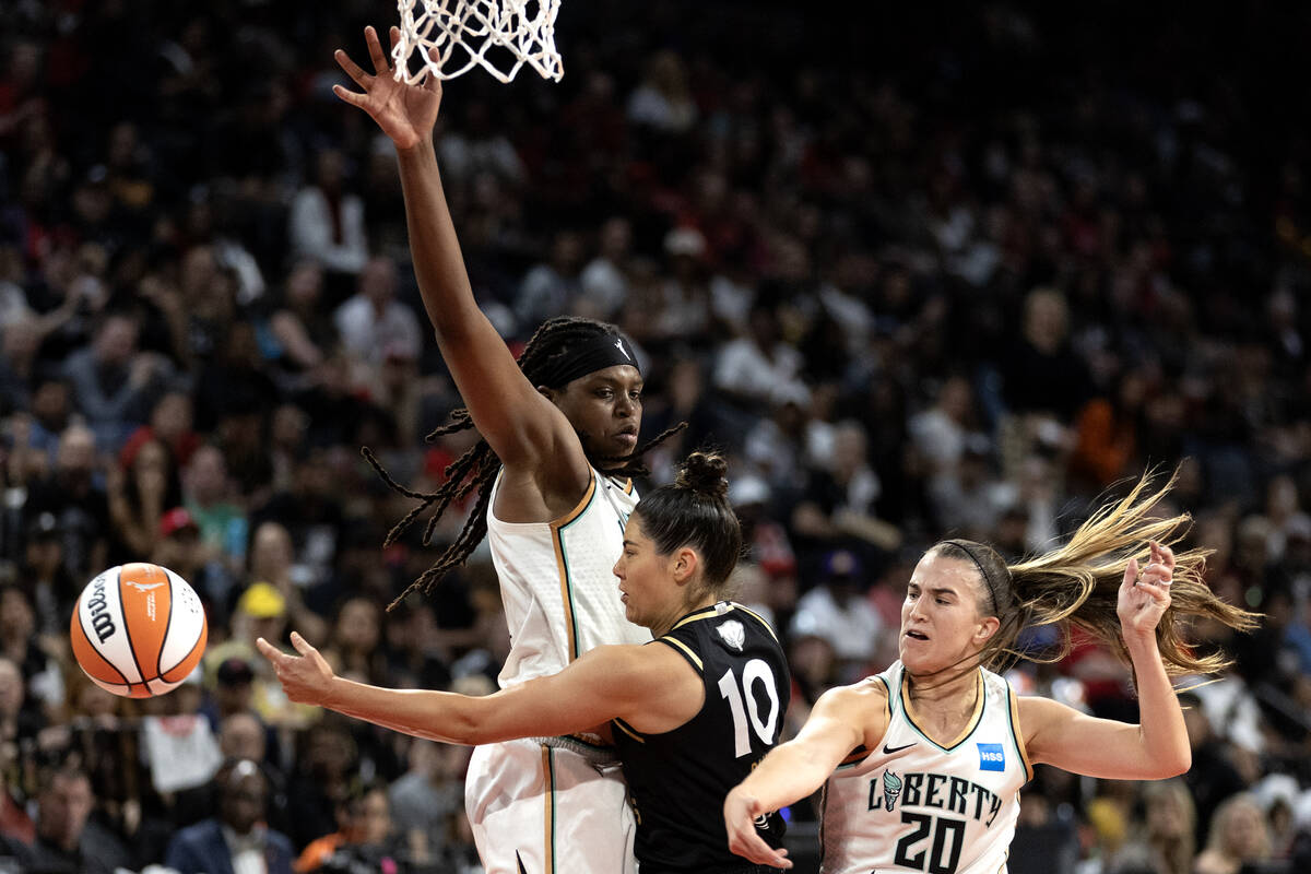 Las Vegas Aces guard Kelsey Plum (10) opts out of shooting to pass between New York Liberty for ...
