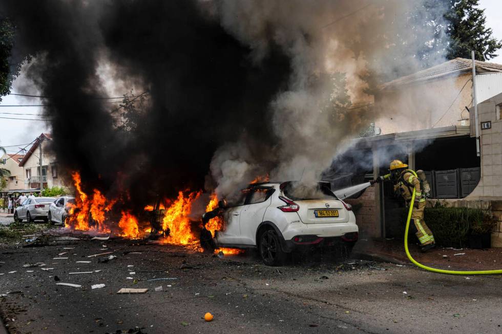 Israeli firefighters extinguish fire at a site struck by a rocket fired from the Gaza Strip in ...