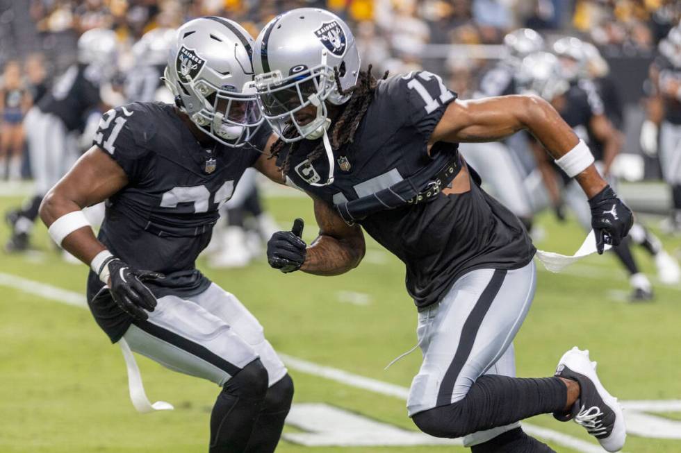 Raiders wide receiver Davante Adams (17) works against cornerback Amik Robertson (21) before an ...