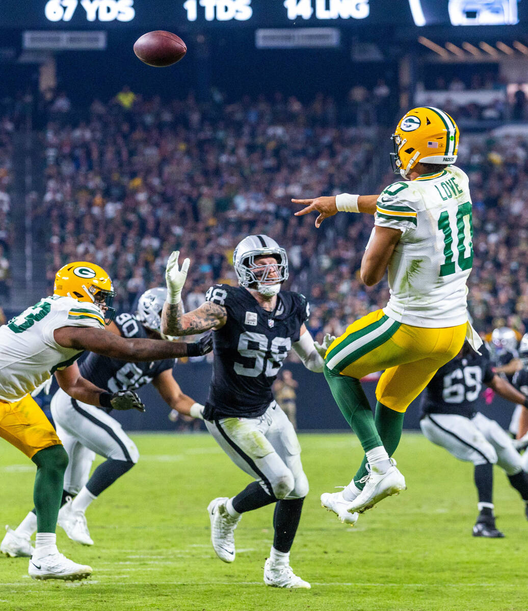 Green Bay Packers quarterback Jordan Love (10) elevates to pass over a rush by Raiders defensiv ...