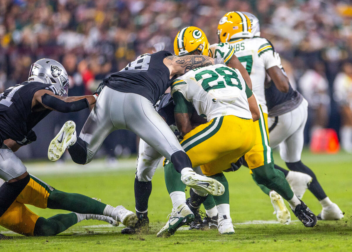 Raiders defensive end Maxx Crosby (98) leaps in to stop Green Bay Packers running back AJ Dillo ...