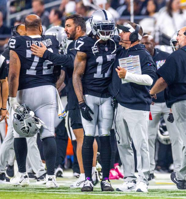 Raiders wide receiver Davante Adams (17) talks closely with Raiders head coach Josh McDaniels o ...