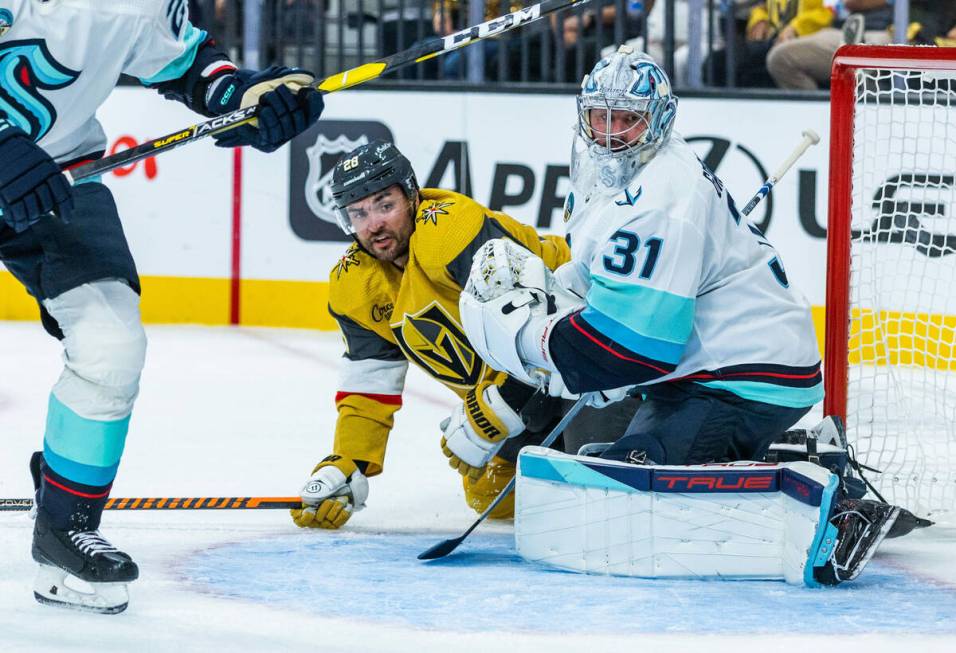 Golden Knights left wing William Carrier (28) and Seattle Kraken goaltender Philipp Grubauer (3 ...